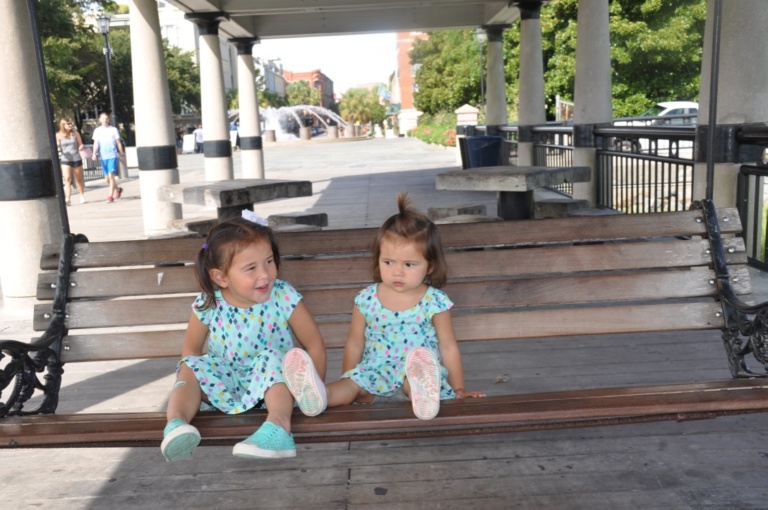 Two toddlers sitting side by side on outdoor steps