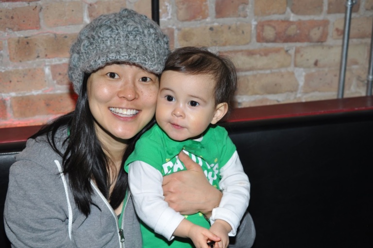 A mother in a knit hat holding her toddler