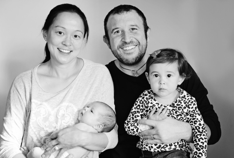 Black and white family portrait with a newborn and a toddler