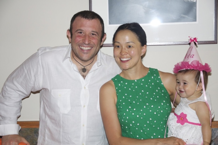 Parents with their daughter in a party hat at her birthday