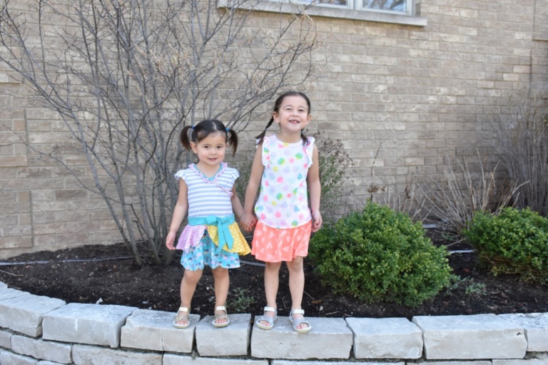 Two young girls standing outside a house