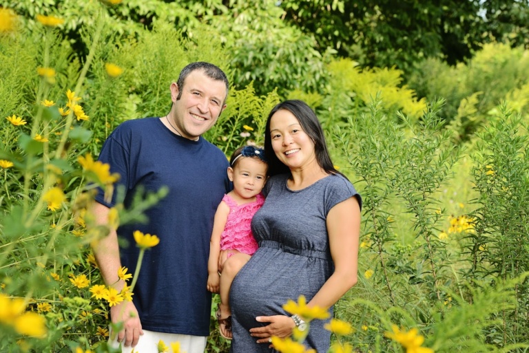 A couple with their toddler among yellow wildflowers