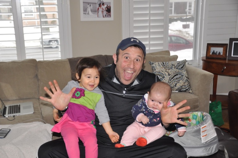 A father on a couch with his two small children