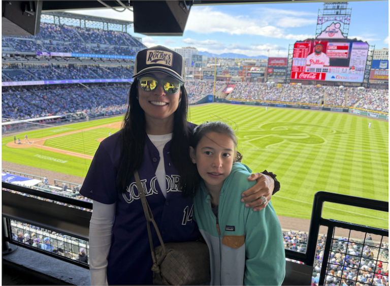 A mother and daughter in the stands at a baseball game