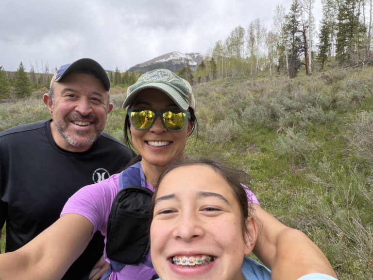A family selfie on a green hillside
