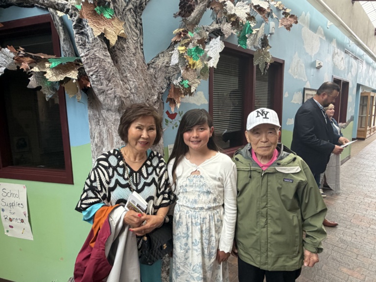 The family posing outside a brightly painted shop